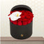 Damascus premium flower box featuring a heart-like arrangement of red roses and a single white orchid in a matte black hatbox on a wooden table.