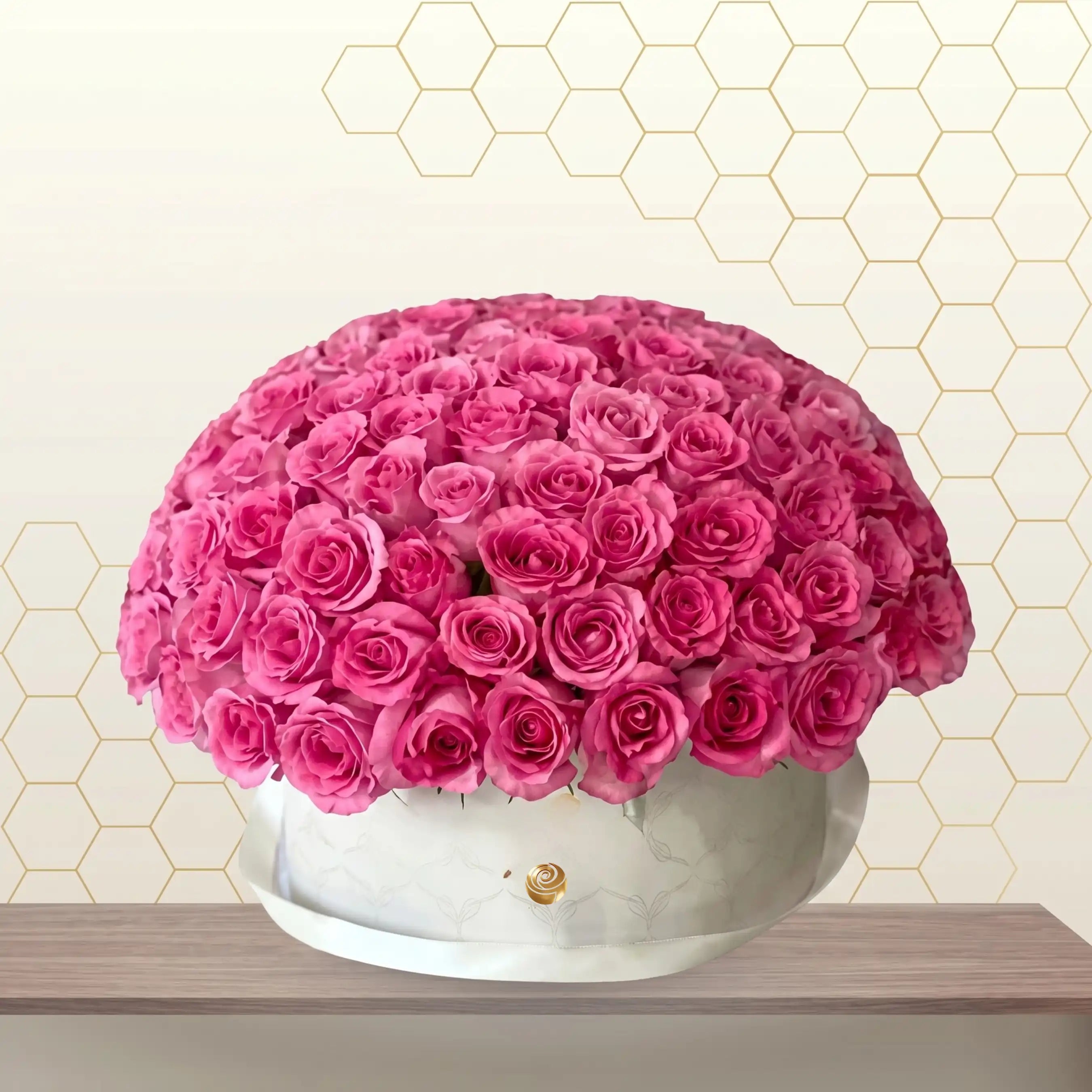 Bouquet of pink roses in a silver container against a hexagonal patterned wall.
