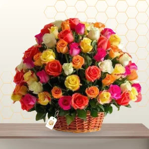Large wicker basket overflowing with 100 vibrant mixed-color roses in a lush floral arrangement. Main image
