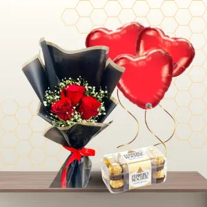 Small bouquet of red roses and baby's breath in black wrapping, next to a box of chocolates and three heart balloons. Main image