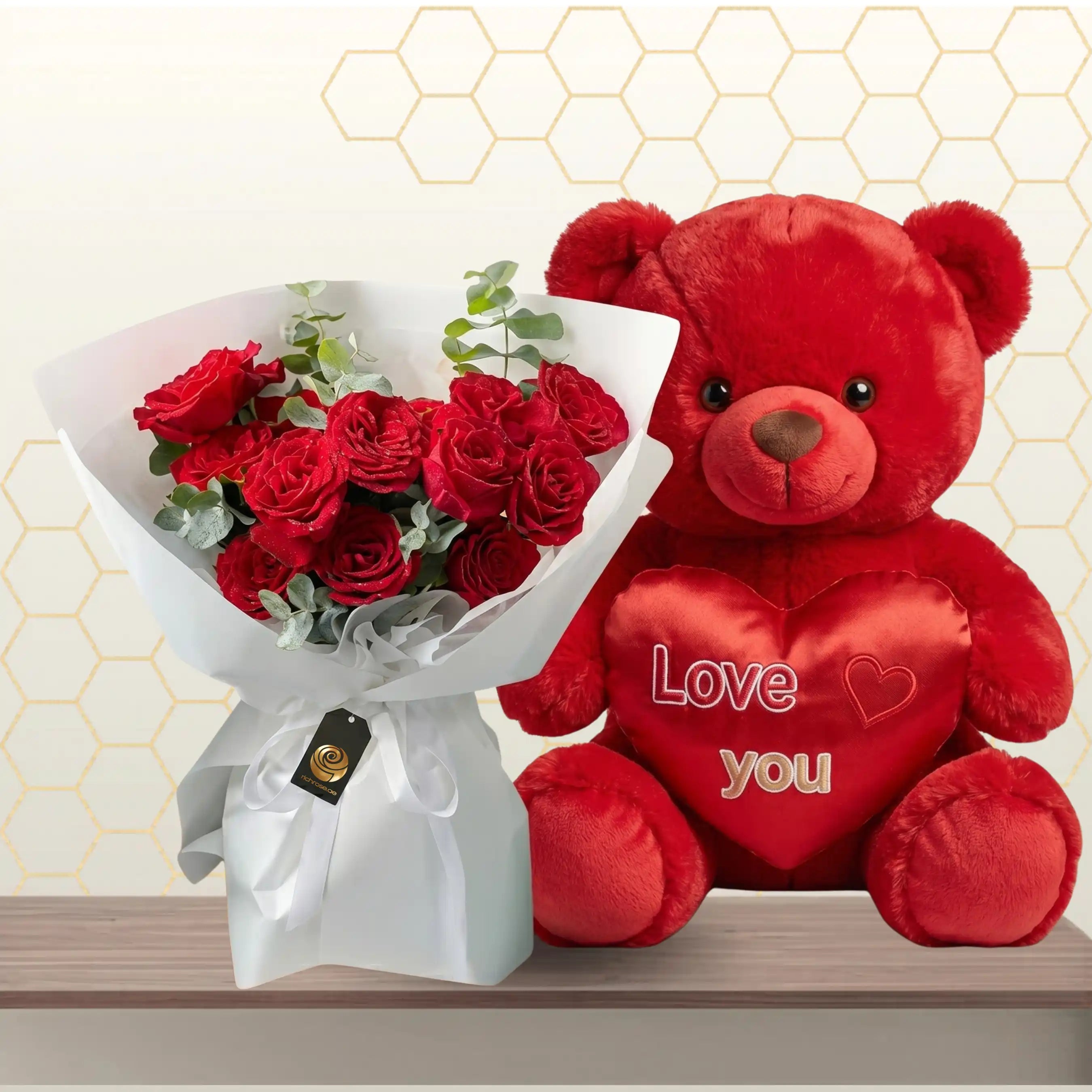 Red rose bouquet in white wrapping sitting next to a giant 90cm red teddy bear.