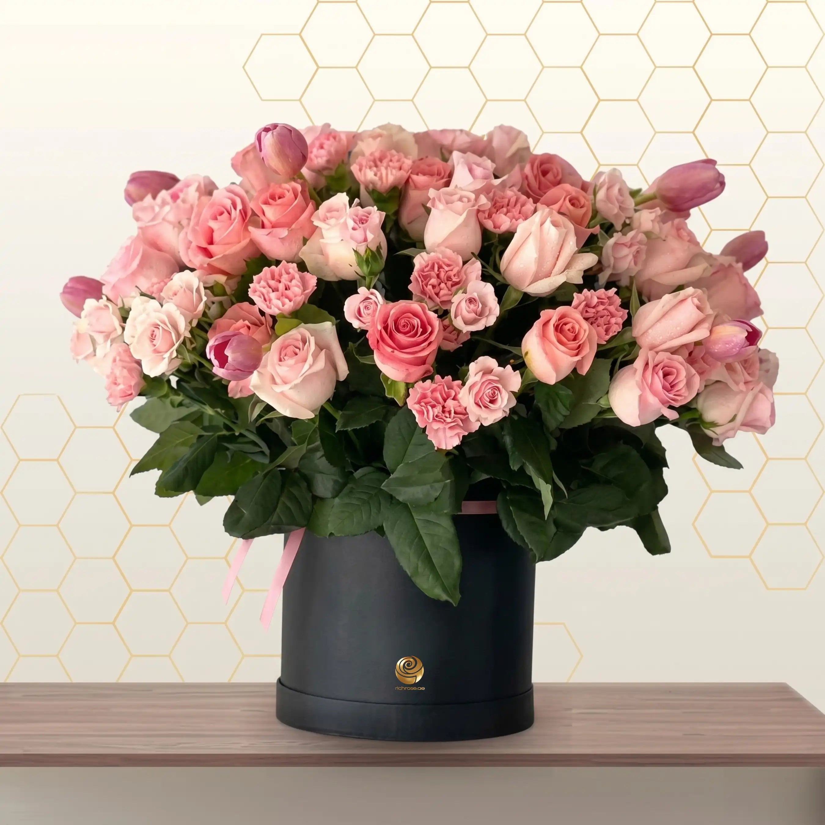 honey bun - Bouquet of pink and white roses in a black box on a wooden surface with a light background