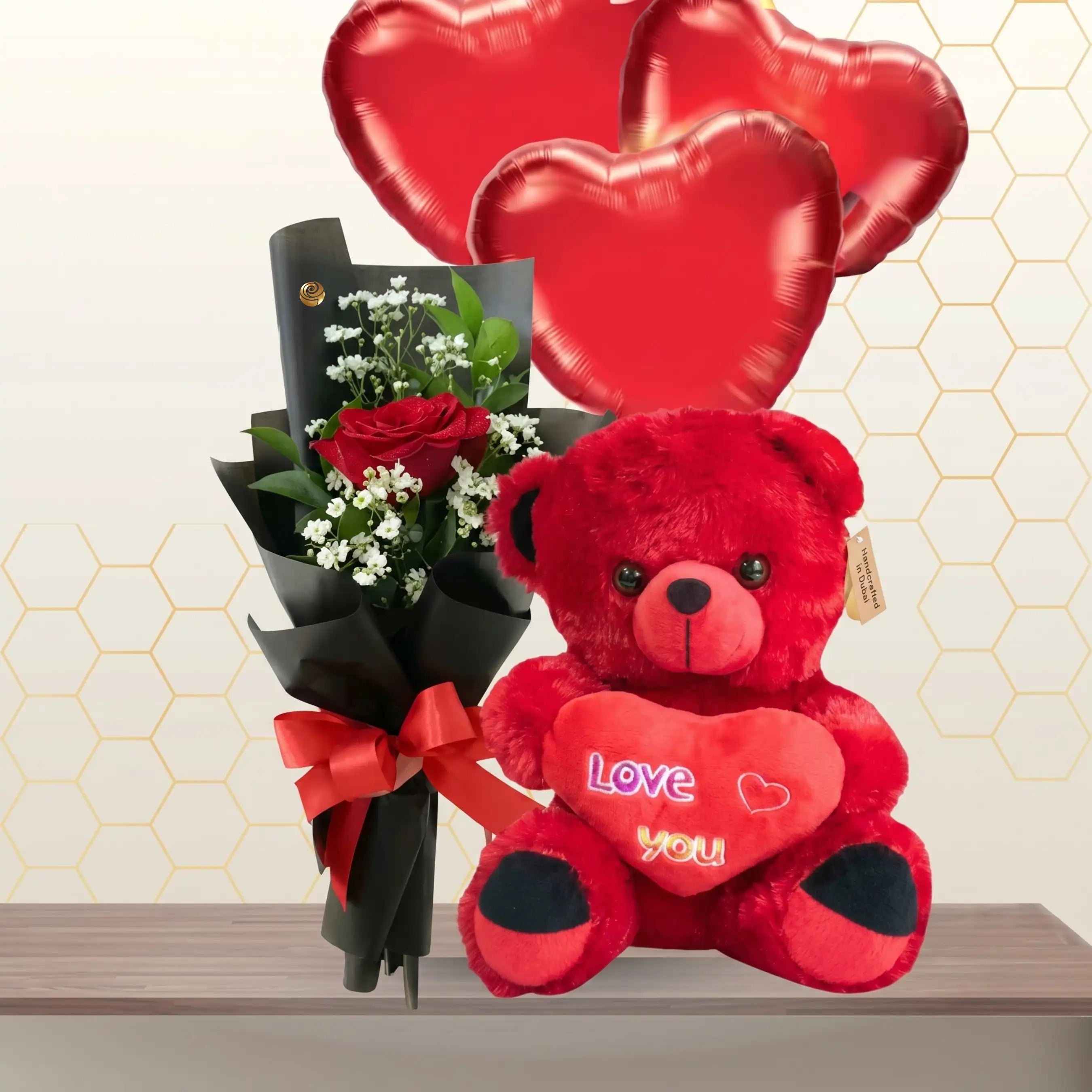 Small bouquet of red roses next to a large 60cm red teddy bear and three red heart-shaped balloons.